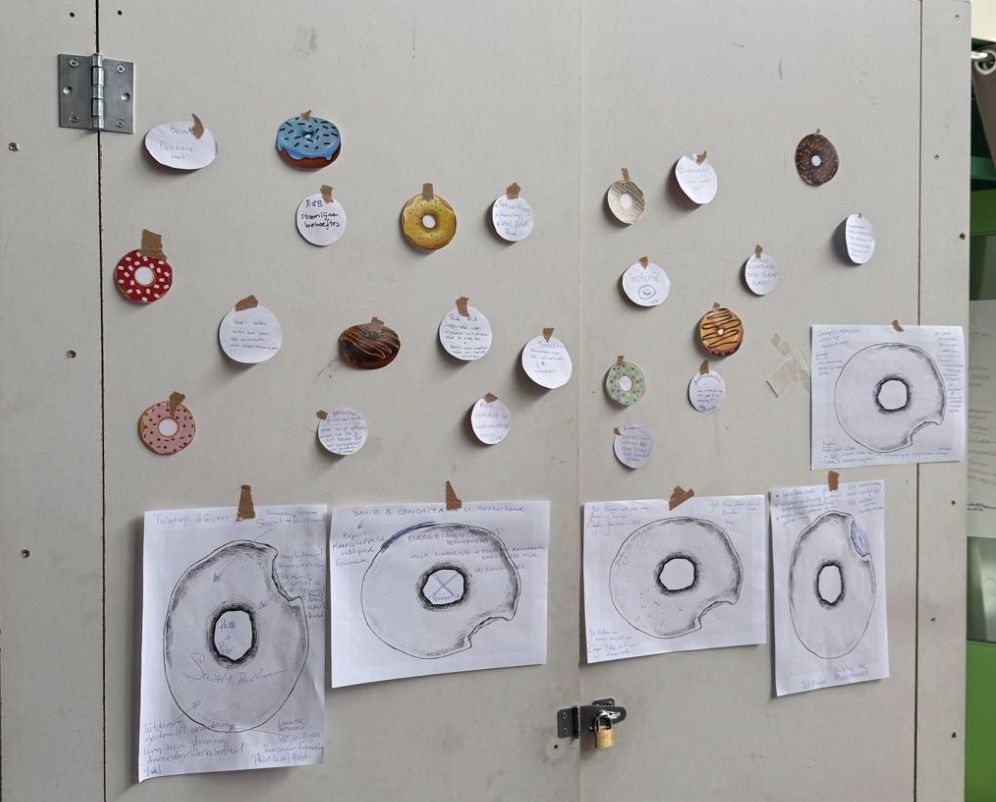 A wall with paper donut cards and drawings of donuts made by participants.